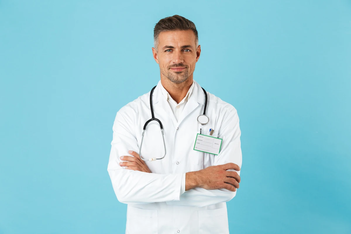 Digital Marketing Strategies for Harley Street Clinics. A Healthcare professional in a white coat and stethoscope round neck, arms crossed, looking content on a turquoise background